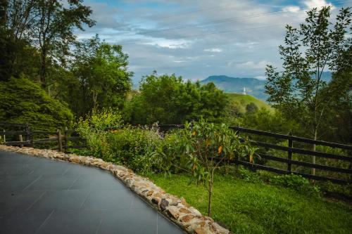 a garden with a stone walkway next to a fence at Refined cabin, panoramic views, steps from Jericó in Jericó