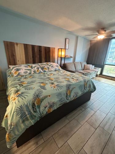 a bedroom with a bed with a colorful comforter at Single or Double Beach Studio Oceanfront Pool & Tiki in Daytona Beach Shores