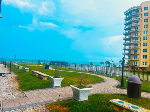 a park near the beach with benches and a building at Single or Double Beach Studio Oceanfront Pool & Tiki in Daytona Beach Shores