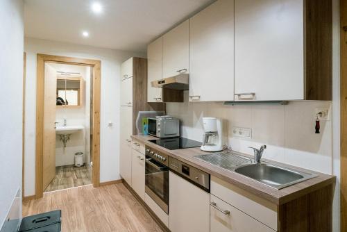 a kitchen with a sink and a microwave at Haus Schennach in Mayrhofen