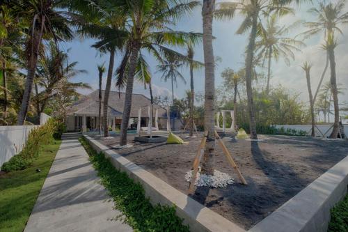 a playground with palm trees in front of a house at Saba Villa by Sanga Sanga Hospitality in Saba