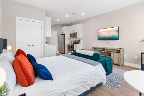 a bedroom with a large bed with colorful pillows at Charming Studio with Breathtaking Pier and Bridge Views in Philadelphia