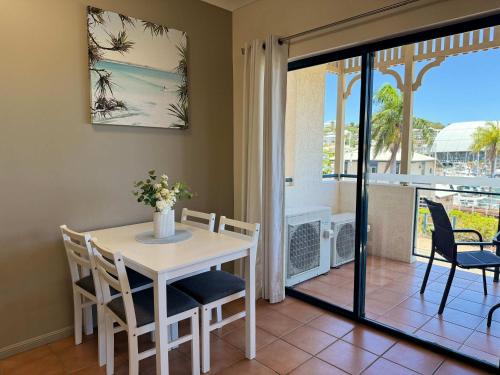 a dining room with a table and chairs and a balcony at Marina View Apartment - Steps away from CBD, Ferry & Stadium in Townsville in Townsville