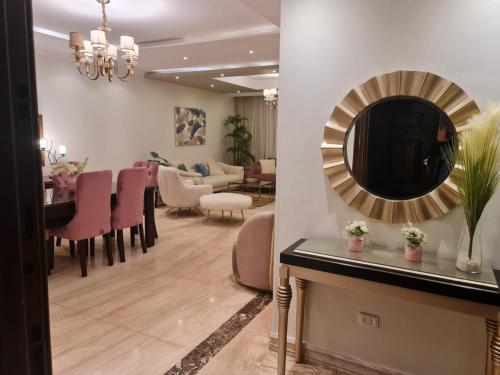 a living room with a mirror and a dining room at AUC park home in Cairo