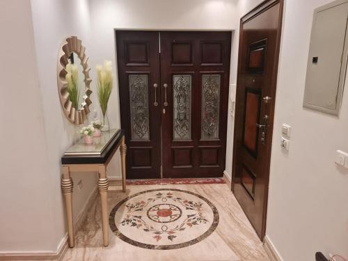 aoyer with a wooden door and a table with a mirror at AUC park home in Cairo