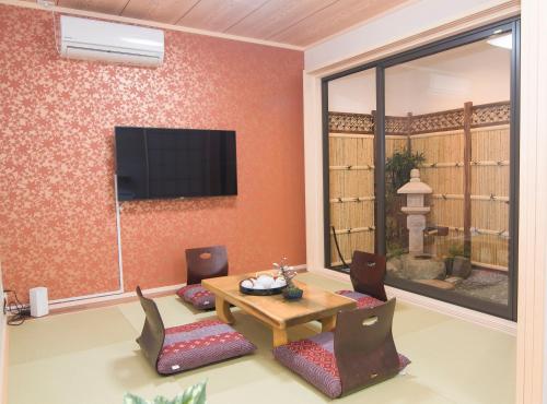 a living room with a table and chairs and a television at 青羽-柏檐 in Osaka