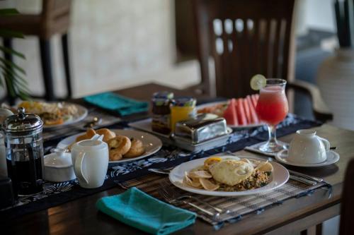 a table with plates of food and drinks on it at Saba Villa by Sanga Sanga Hospitality in Saba