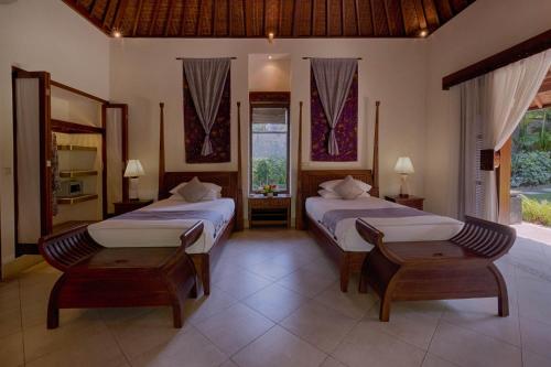 a bedroom with two beds and a window at Saba Villa by Sanga Sanga Hospitality in Saba