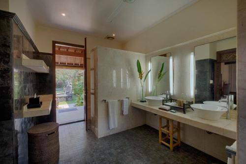a bathroom with two sinks and a large mirror at Saba Villa by Sanga Sanga Hospitality in Saba