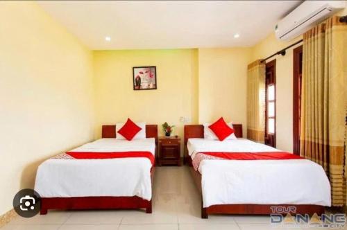 a hotel room with two beds with red pillows at My Trà Hotel in Nam Ðịnh