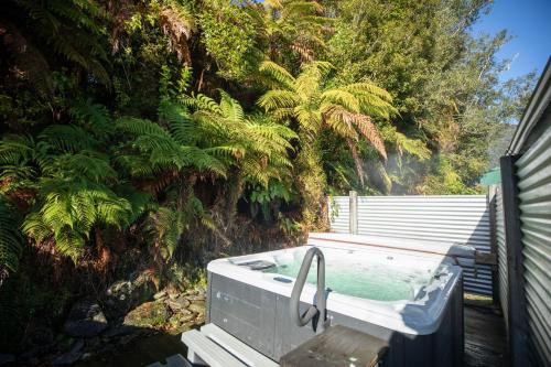 a bath tub sitting in front of a garden at Ivorytowers Accommodation in Fox Glacier