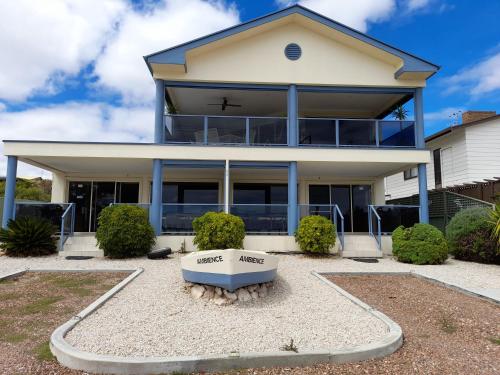a large white house with a large front yard at Ambience Apartments 1 in Coffin Bay