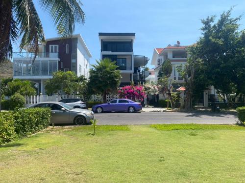 two cars parked in a parking lot in front of buildings at M Villa Nha Trang in Nha Trang