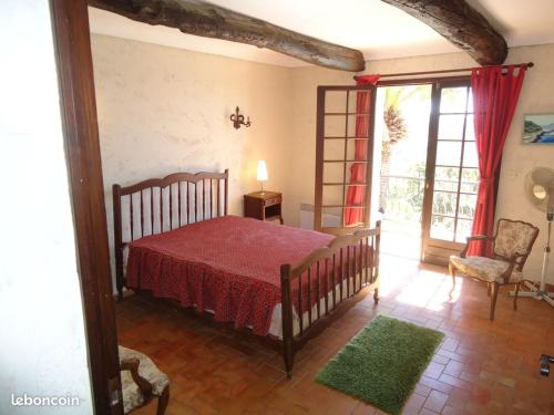 - une chambre avec un lit doté d'un couvre-lit rouge dans l'établissement La Pastourelle, à Roquebrune-sur Argens