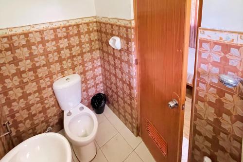 a bathroom with a white toilet in a room at Durhan White Beach Resort powered by Cocotel in Tabuelan