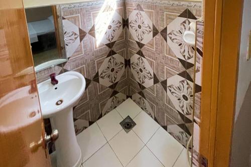 a bathroom with a sink and a tiled wall at Durhan White Beach Resort powered by Cocotel in Tabuelan