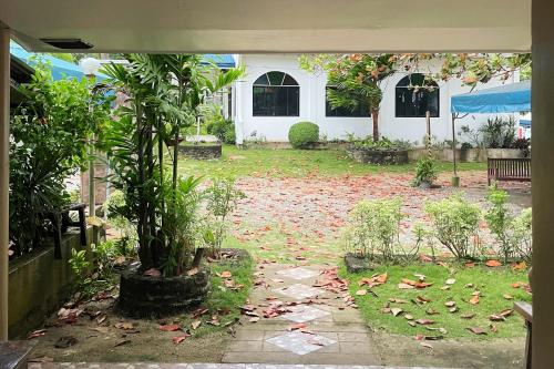 a garden with a tree in the middle of a yard at Durhan White Beach Resort powered by Cocotel in Tabuelan