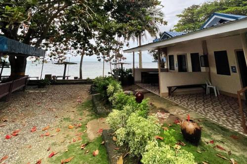 a house with a garden in front of the water at Durhan White Beach Resort powered by Cocotel in Tabuelan