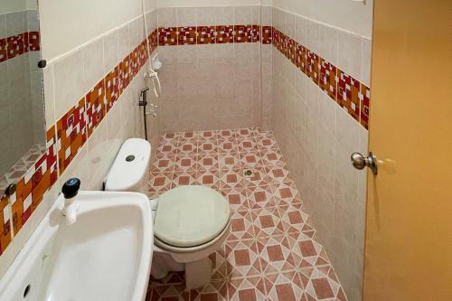 a small bathroom with a toilet and a sink at Durhan White Beach Resort powered by Cocotel in Tabuelan