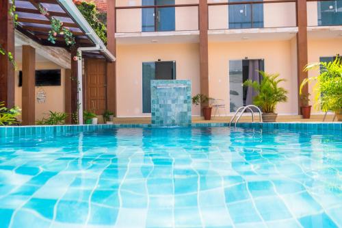a swimming pool in front of a villa at Pousada Cairu in Morro de São Paulo