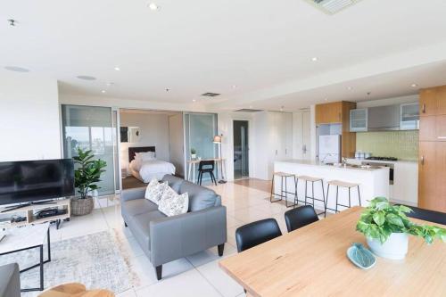 a living room with a couch and a table at Liberty 727 -Glenelg- Marina & City Views in Glenelg