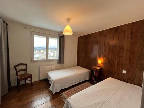 une chambre avec deux lits et une chaise et une fenêtre dans l'établissement Appartement cosy 2 pièces au cœur de Villard de Lans - FR-1-761-45, à Villard-de-Lans