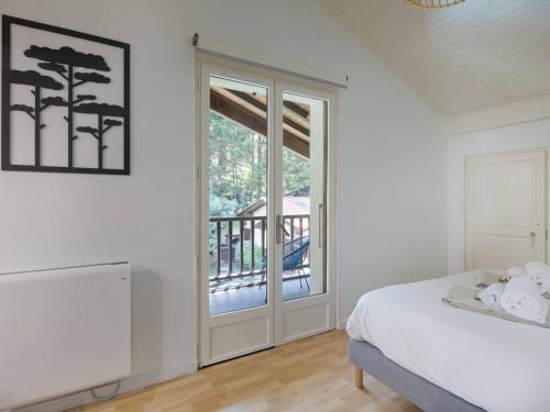 une chambre avec un lit et une porte coulissante en verre dans l'établissement Villa élégante avec piscine privée et Wi-Fi à Capbreton, proche plages - FR-1-791-27, à Capbreton