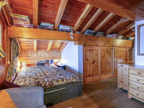 une chambre avec un lit dans une pièce aux murs en bois dans l'établissement Charmant duplex avec cheminée, parking et WiFi à Val-d'Isère - FR-1-694-368, à Val dʼIsère