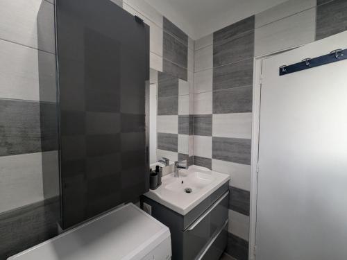 ein Badezimmer mit einem weißen Waschbecken und einer Toilette in der Unterkunft Confort en famille proche de Giffaumont - FR-1-611-112 in Braucourt