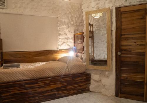 a bedroom with a bed and a mirror and a door at Las Golondrinas Ayampe in Ayampe
