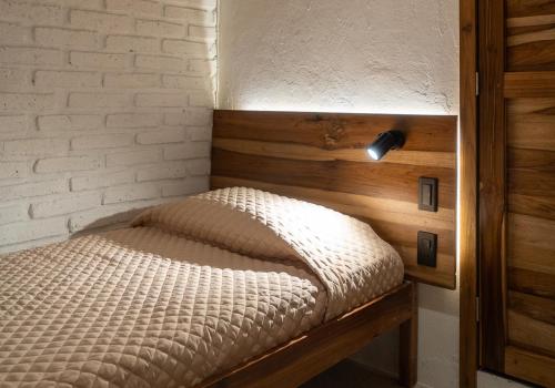 a small bed in a room with a brick wall at Las Golondrinas Ayampe in Ayampe