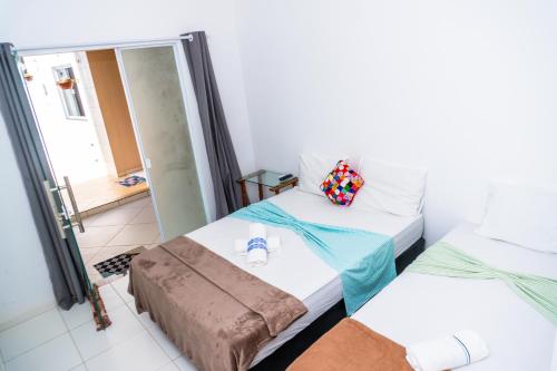 a room with two beds and a mirror at Pousada Cairu in Morro de São Paulo