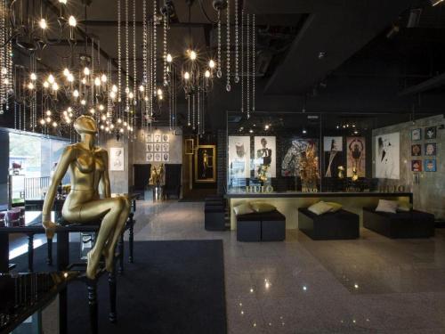 a room with a statue of a woman sitting on a chair at The Hulo Hotel & Gallery in Kuala Lumpur
