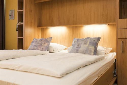 une chambre avec deux lits avec une tête de lit dans l'établissement Haus-Ornum-1-OG-O-Wohnung-13, à Westerland