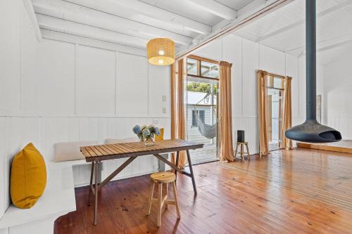 a dining room with a wooden table and a fireplace at Hinterland Views in Lennox Head