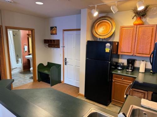 a kitchen with a black refrigerator and a sink at Ski-In Ski-Out Condo at Zephyr Mountain Lodge 1518 in Winter Park