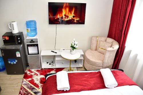 a room with a bed and a chair and a fireplace at Haydenco Suites Furnished Studios in Nairobi