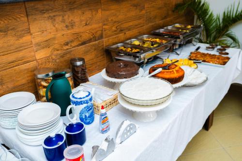 a table topped with plates and cakes and other food at Pousada Cairu in Morro de São Paulo