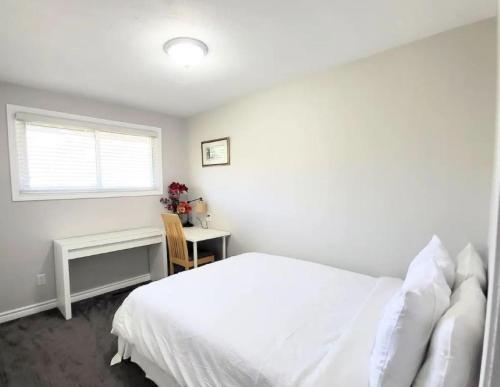 a bedroom with a bed and a desk and a window at Cozy Home in Niagara-on-the-Lake in Niagara on the Lake