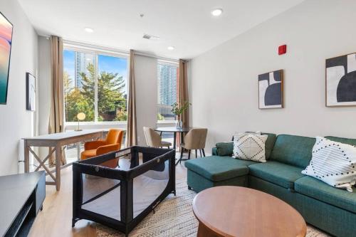 a living room with a green couch and a table at King Bed - Stunning Pier Views - Near Fishtown in Philadelphia