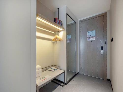 pasillo con escritorio y puerta con espejo en Echarm Hotel Fangchenggang Administration Center High Speed Railway Station, en Gongche