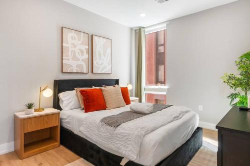 フィラデルフィアにあるAmazing City Views - Sleeps 6 - Near Fishtownのオレンジ色の枕が付いた大きなベッドのある寝室
