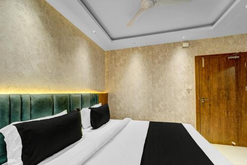 a bedroom with a large bed with a green headboard at Super Townhouse La Vista in Rānchī