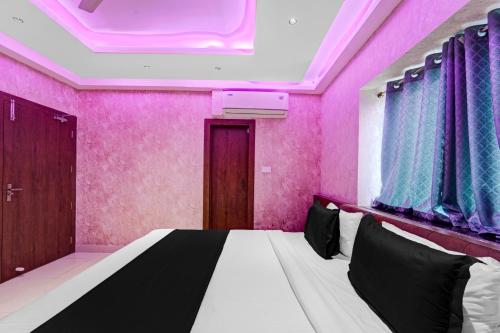 a bedroom with a bed in a room with pink walls at Super Townhouse La Vista in Rānchī