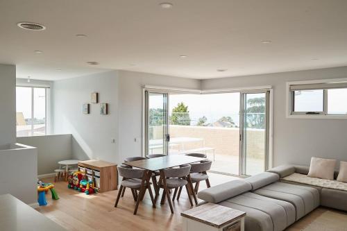 a living room with a couch and a table at Harbour Horizons - Balcony BBQs and Calm Water Views in Clifton Springs