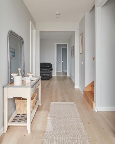 a living room with a table and a mirror at Harbour Horizons - Balcony BBQs and Calm Water Views in Clifton Springs