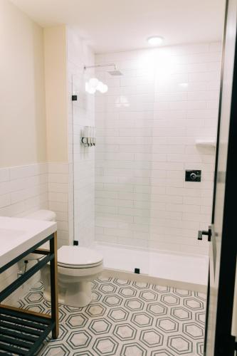 a white bathroom with a toilet and a shower at The St. Clair in Frankfort