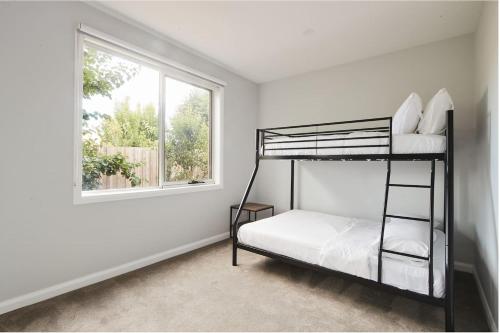 a bedroom with two bunk beds and a window at Harbour Horizons - Balcony BBQs and Calm Water Views in Clifton Springs