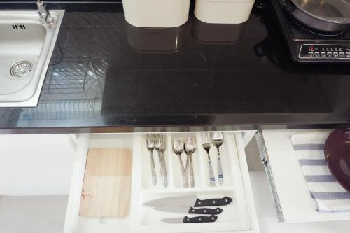 a drawer with silver utensils in a kitchen at Cozy Living in Bangkok 60m to MRT near chatuchank in Bang Su