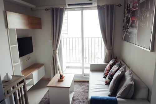 a living room with a couch and a large window at Cozy Living in Bangkok 60m to MRT near chatuchank in Bang Su